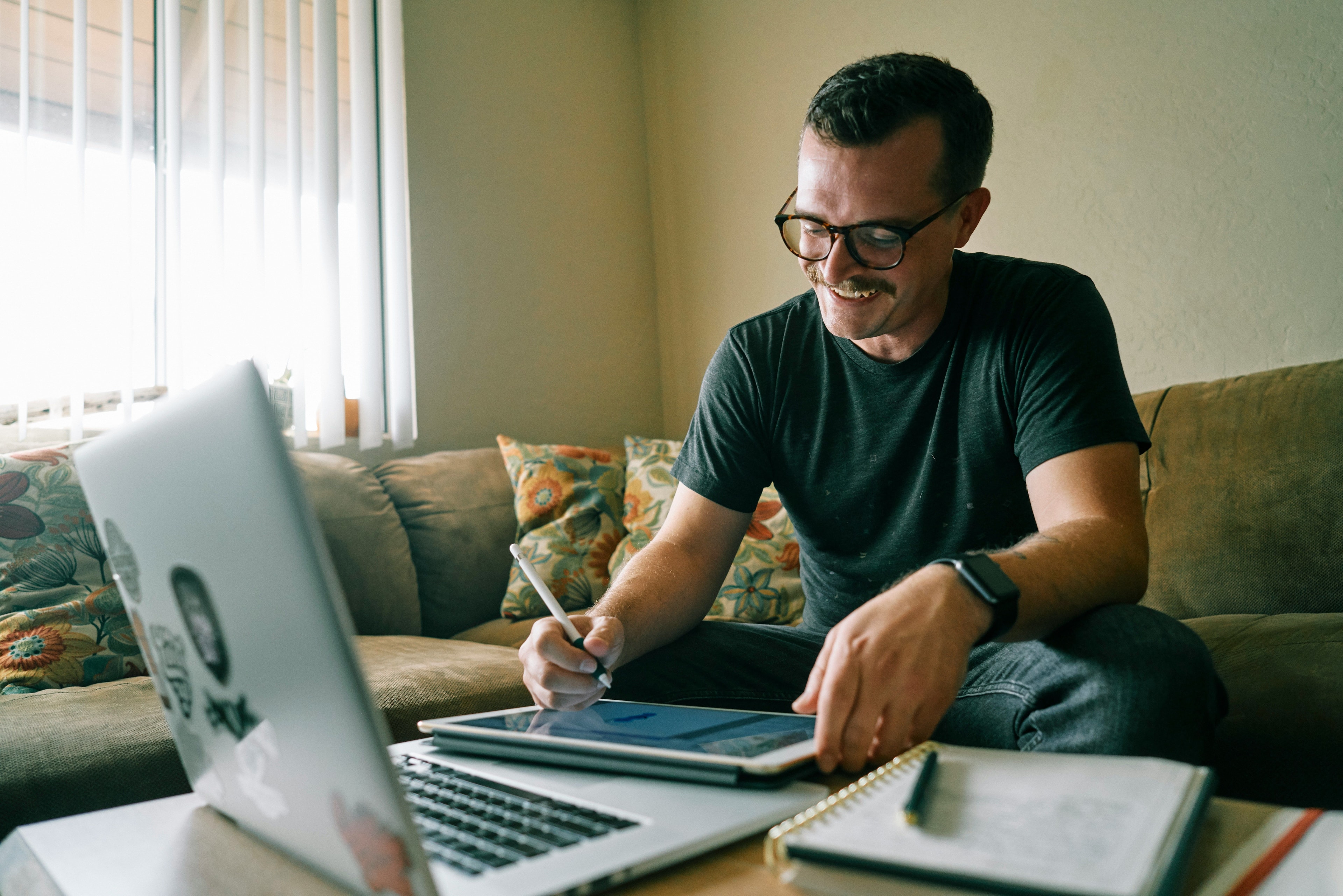 Man going through documents while working on laptop